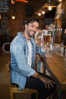 Smiling man holding beer glass at restaurant
