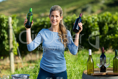 Portrait of smiling woman holding wine bottles