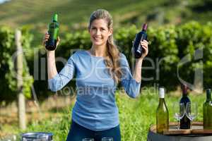 Portrait of smiling woman holding wine bottles