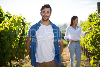 Smiling young man standing at vineyard