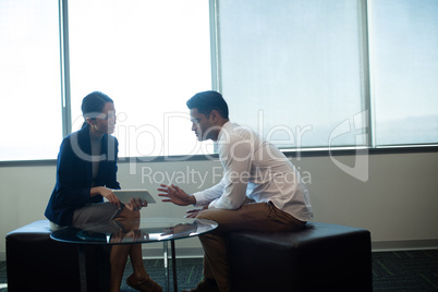 Business people discussing over digital tablet at office