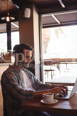 Man using laptop while having coffee