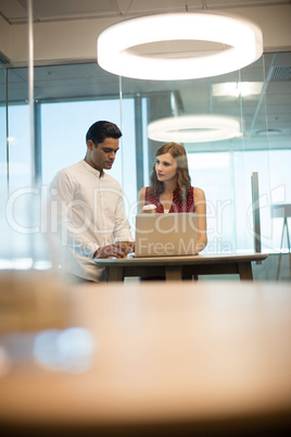 Business people discussing over laptop in office