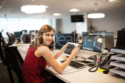 Portrait of smiling businesswoman holding digital tablet in office