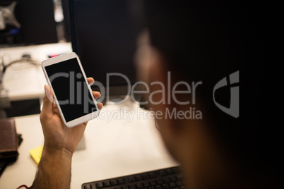 Businessman holding mobile phone in office