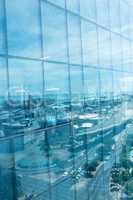 Office building with reflection of city against sky