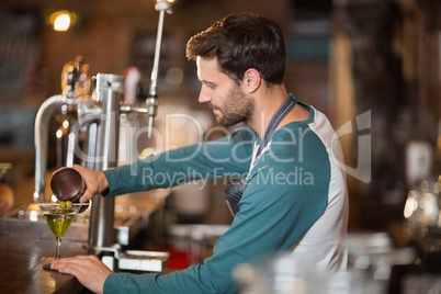 Side view of bartender making drinks