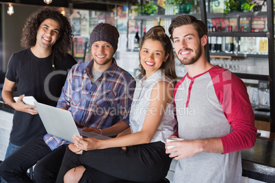 Smiling friends using laptop in restaurant Smiling friends using laptop in restaurant