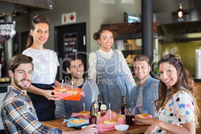 Group of friends with waitress in restaurant