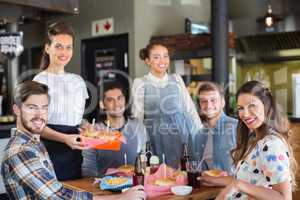 Group of friends with waitress in restaurant