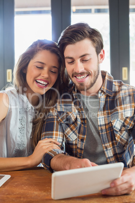 Cheerful young man and woman using tablet pc