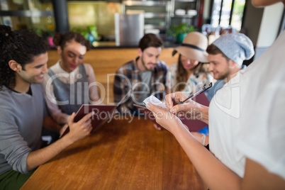 Waitress taking orders of customers in restaurant