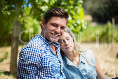 Woman sleeping on man shoulder at vineyard