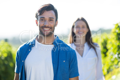 Happy young man standing at vineyard