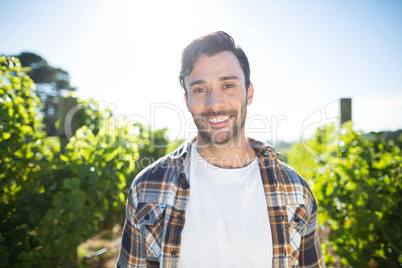 Portrait of young man standing at vineyard