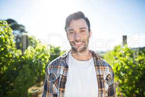 Portrait of young man standing at vineyard