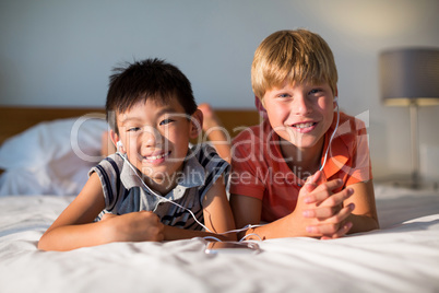 Portrait of siblings listening to music on mobile phone