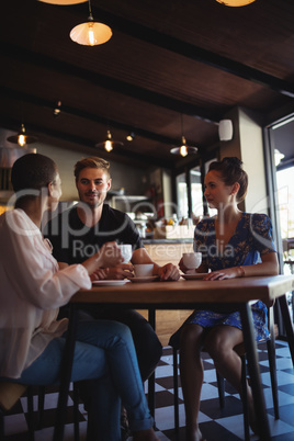 Happy friends interacting while having coffee