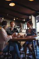 Happy friends interacting while having coffee