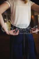 Waitress tying apron at restaurant