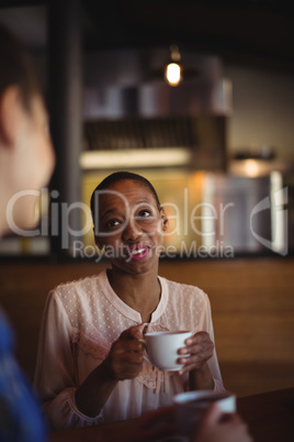 Happy friends interacting while having coffee