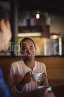 Happy friends interacting while having coffee