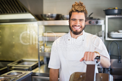 Smiling male chef standing in commercial kitchen