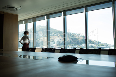 Businesswoman looking through window in conference room