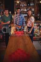 Group of happy friends playing beer pong game