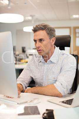 Serious businessman working on computer in office