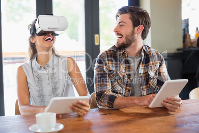 Man looking at friend wearing virtual reality glasses