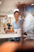 Smiling businesswoman discussing with male colleague in office