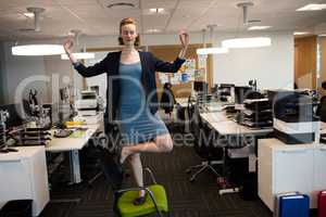 Businesswoman practicing yoga at office