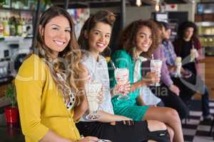 Female friends drinking smoothie at restaurant