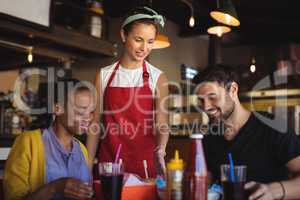 Waitress serving burger and french fries to customer