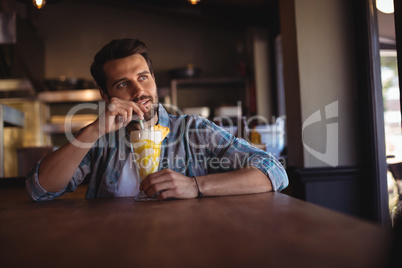 Thoughtful man having milkshake