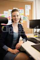 Portrait of businesswoman sitting on chair at office