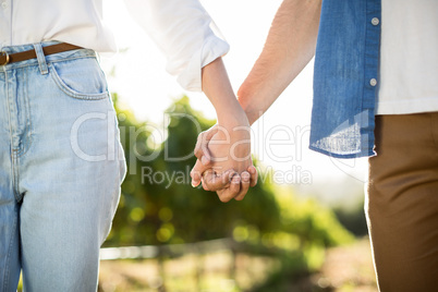 Mid section of couple holding hands
