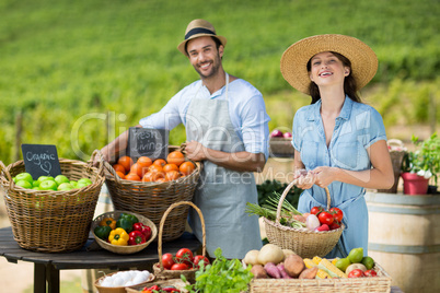 Smiling friends selling fruits and vegetables