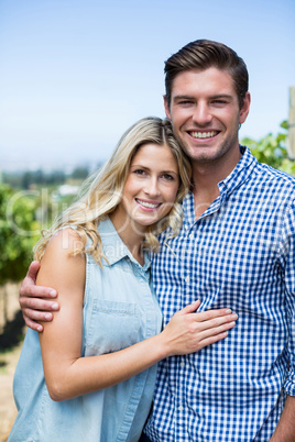Portrait of happy couple embracing at vineyard