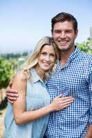 Portrait of happy couple embracing at vineyard