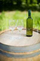 Empty wineglasses and bottle on barrel