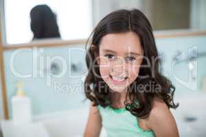 Girl smiling at camera in bathroom