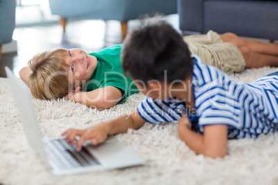 Siblings interacting with each other while using laptop