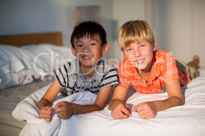 Portrait of smiling sibling lying on bed