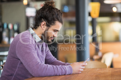 Young man using mobile phones in restaurant