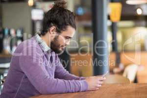 Young man using mobile phones in restaurant