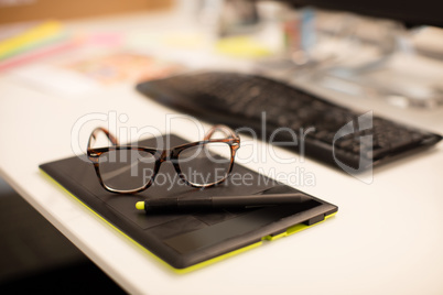 High angle view of eyeglasses on digitizer at desk