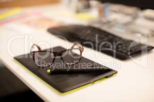 High angle view of eyeglasses on digitizer at desk