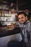 Portrait of happy man having beer at counter